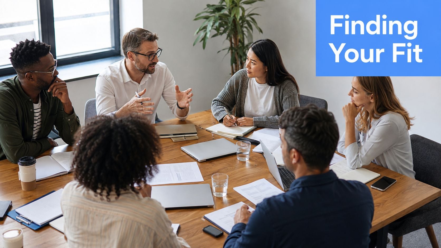 A professional team of diverse colleagues having a productive business meeting around a wooden conference table.